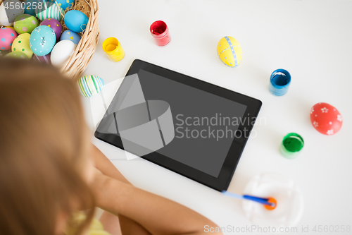 Image of girl with tablet computer, easter eggs and colors