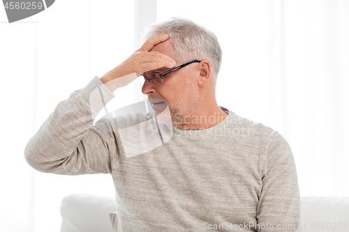 Image of senior man suffering from headache at home