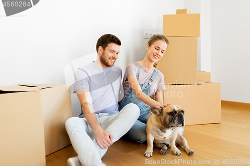 Image of happy couple with boxes and dog moving to new home