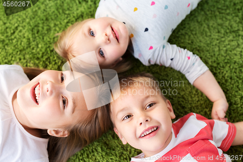 Image of happy little kids lying on floor or carpet