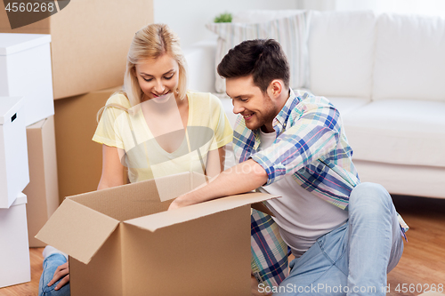 Image of happy couple unpacking boxes at new home