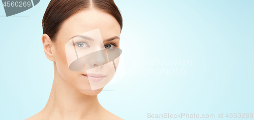 Image of face of beautiful woman over blue background