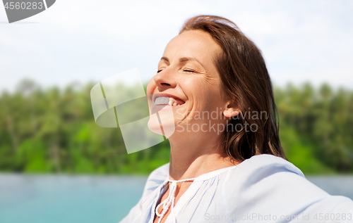 Image of happy woman over tropical beach background