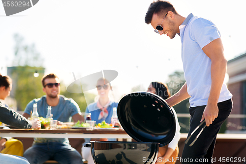 Image of man grilling on bbq at rooftop party