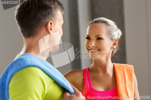 Image of happy couple with towels in gym