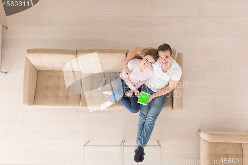 Image of young couple in living room using tablet top view