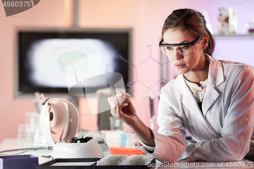 Image of Portrait of a confident female researcher in life science laboratory writing structural chemical formula on a glass board.