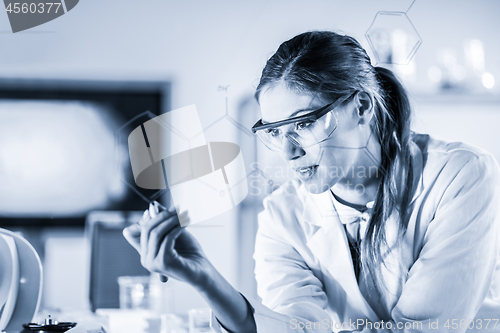 Image of Portrait of a confident female researcher in life science laboratory writing structural chemical formula on a glass board.