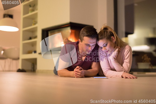 Image of Young Couple using digital tablet on cold winter night