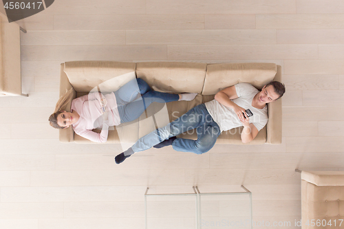 Image of Young couple on the sofa watching television top view