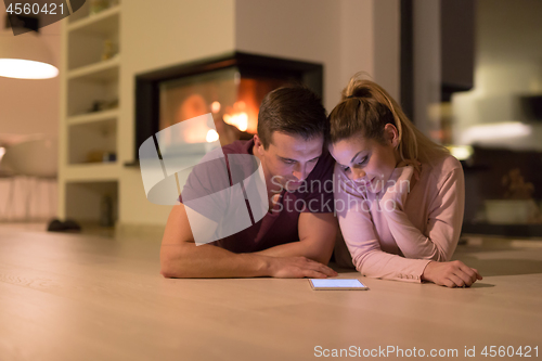 Image of Young Couple using digital tablet on cold winter night