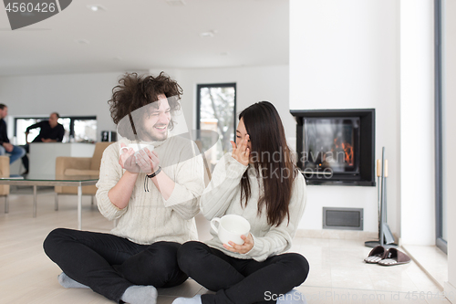 Image of happy multiethnic couple  in front of fireplace