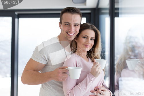 Image of young couple enjoying morning coffee by the window