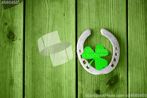 Image of horseshoe with shamrock on green wood boards