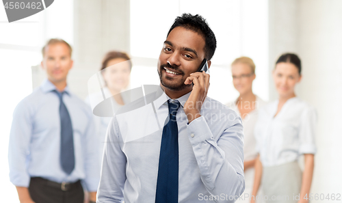 Image of indian businessman calling on smartphone at office