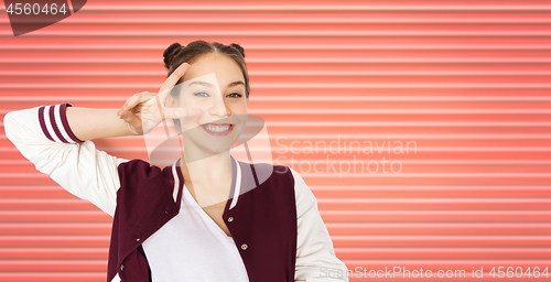 Image of happy smiling teenage girl showing peace sign