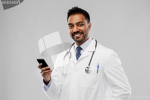 Image of smiling indian male doctor with smartphone