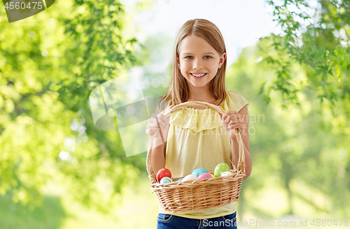 Image of happy girl with colored eggs in wicker basket