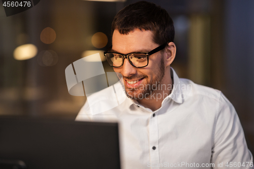 Image of businessman with computer working at night office