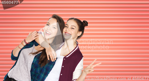 Image of teenage girls or friends hugging and showing peace