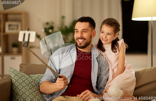 Image of father and daughter taking selfie at home