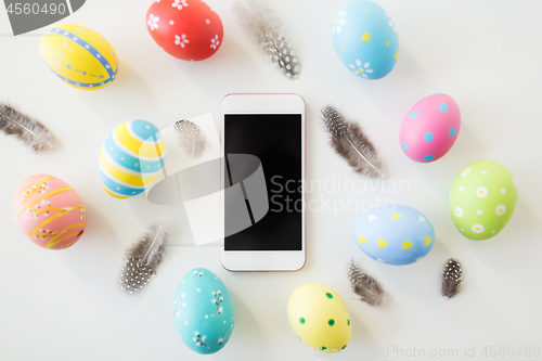 Image of smartphone with easter eggs and quail feathers