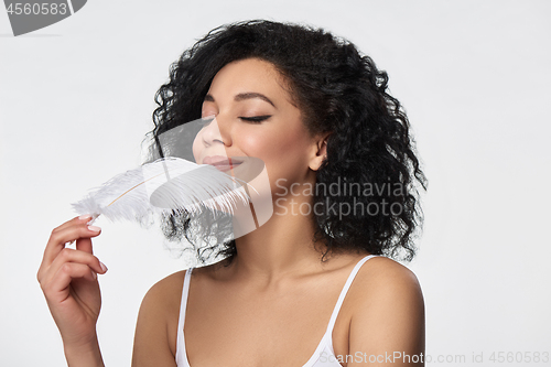 Image of Beautiful mixed race woman holding white ostrich feather