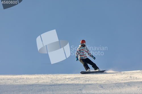Image of Female snowboarder in sun flare