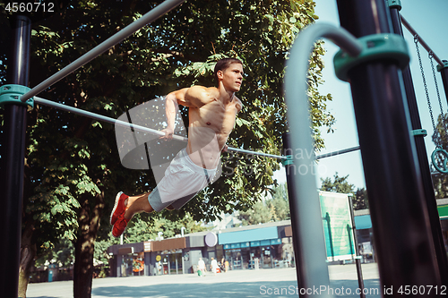 Image of Athlete doing exercises at stadium at park