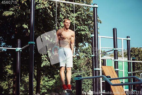 Image of Athlete doing exercises at stadium at park