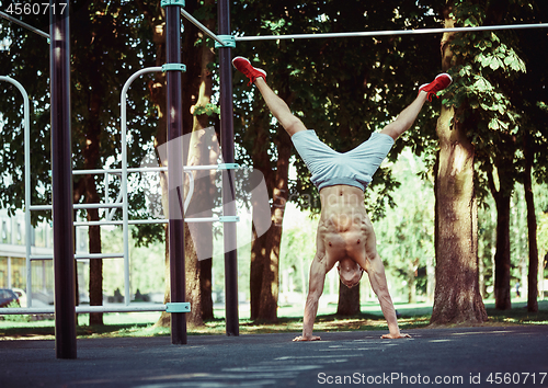 Image of Athlete doing exercises at stadium at park