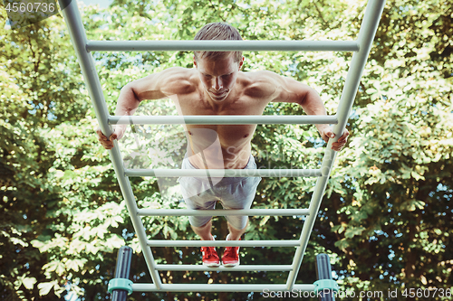 Image of Athlete doing exercises at stadium at park