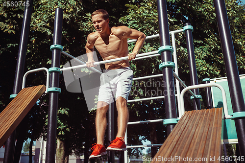 Image of Athlete doing exercises at stadium at park