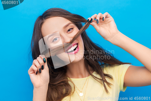 Image of happy young woman making mustache with her hair