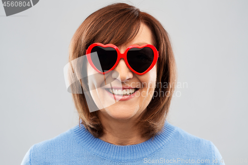 Image of smiling senior woman in heart-shaped sunglasses