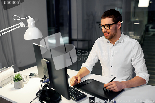 Image of designer with computer and pen tablet at office