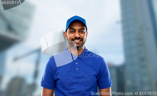 Image of happy indian delivery man in blue uniform