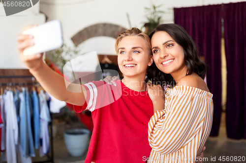 Image of female friends taking selfie at clothing store