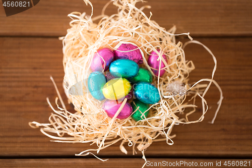 Image of chocolate easter eggs in straw nest on table