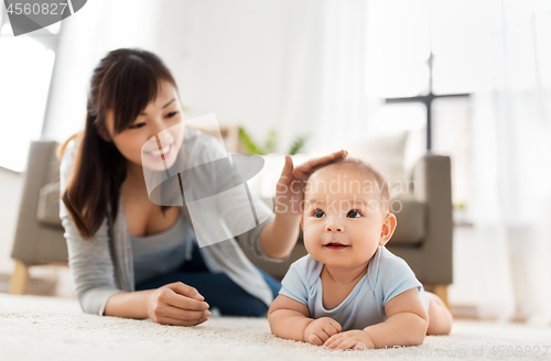 Image of sweet little asian baby boy with mother at home