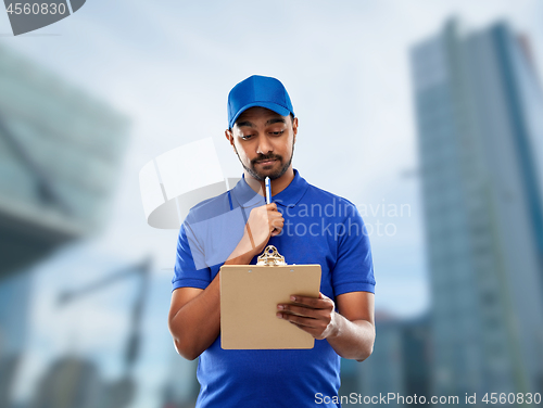 Image of indian delivery man with clipboard in blue