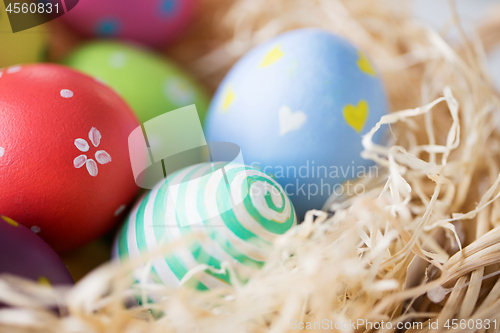 Image of close up of colored easter eggs in straw