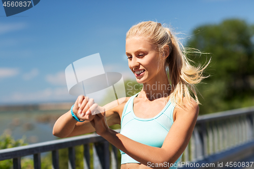 Image of happy woman with fitness tracker exercising