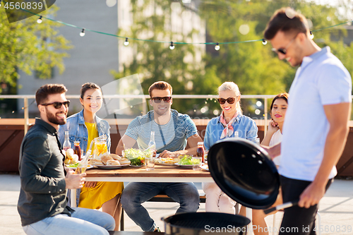 Image of man grilling on bbq at rooftop party