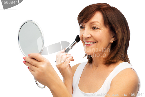 Image of senior woman with mirror and make up blush brush