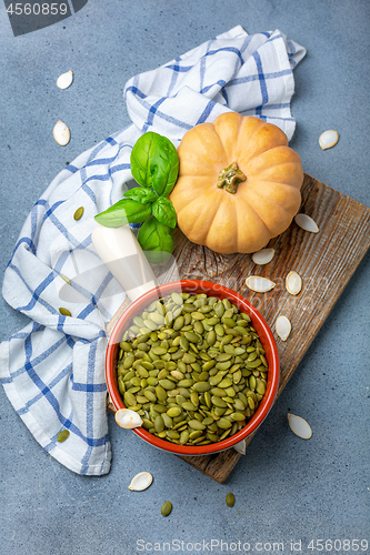 Image of Organic pumpkin seeds in a ceramic bowl.