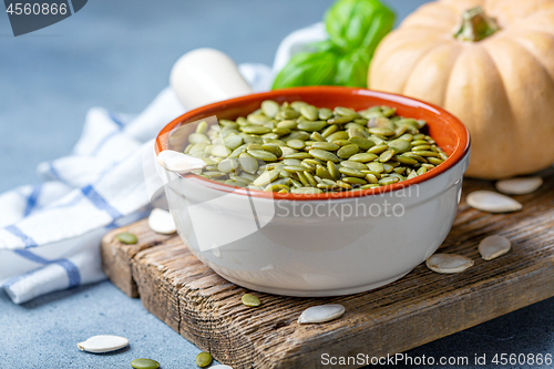 Image of Organic pumpkin seeds in a ceramic bowl.