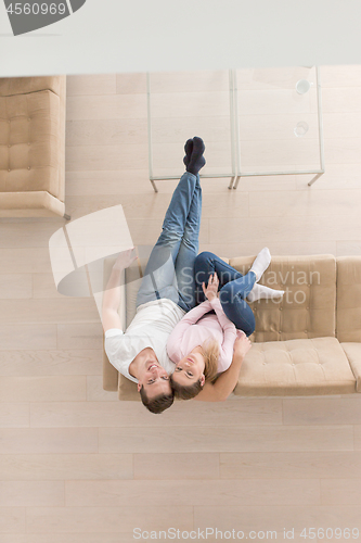 Image of Young couple on the sofa watching television top view