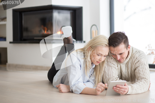 Image of Young Couple using digital tablet on cold winter day