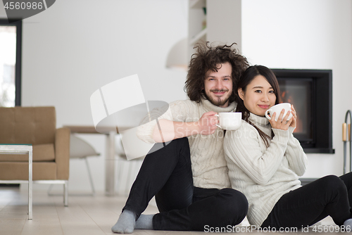 Image of happy multiethnic couple  in front of fireplace